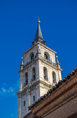Fototapeta na wymiar Holy Children cathedral tower (Santos Niños cathedral) in Alcalá de Henares, Spain. Located in the historical center of the city, the high tower is built in Renaissance style and measures 62 meters. 