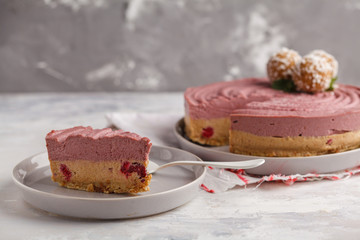 Pink berry caramel raw vegan cheesecake with coconut sweet raw balls. Healthy vegan food concept.