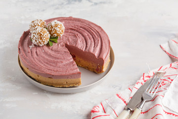 Pink berry caramel raw vegan cheesecake with coconut sweet raw balls. Healthy vegan food concept.