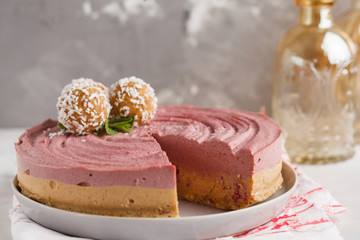 Pink berry caramel raw vegan cheesecake with coconut sweet raw balls. Healthy vegan food concept.