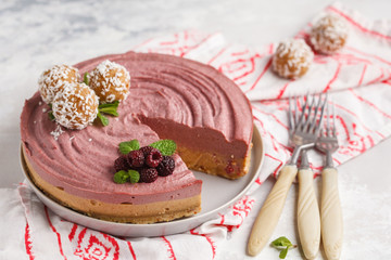 Pink berry caramel raw vegan cheesecake with coconut sweet raw balls. Healthy vegan food concept.