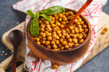 Healthy snack - baked spicy chickpeas in a wooden bowl. Healthy vegan food concept.