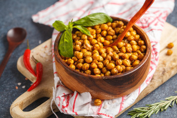 Healthy snack - baked spicy chickpeas in a wooden bowl. Healthy vegan food concept.