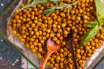 Healthy snack - baked spicy chickpeas in a glass dish, top view. Healthy vegan food concept.