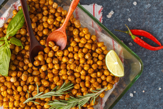 Healthy snack - baked spicy chickpeas in a glass dish, top view. Healthy vegan food concept.