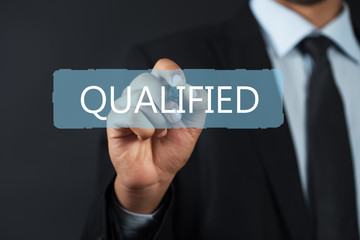 Business man pointing the text: Qualified