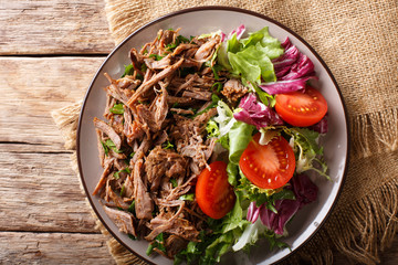 Healthy lunch: tender beef with vegetable salad close-up on a plate. horizontal top view from above