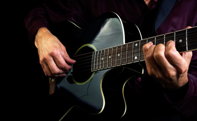 Fototapeta na wymiar Playing an Acoustic Guitar. Closeup. Guitarist hands and guitar 