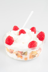 Fruity summer salad in white bowl with yogurt