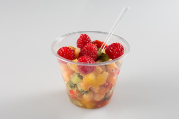 a fruit salad in take away clear plastic cup on white background