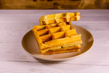 Ceramic plate with belgian waffles on wooden table