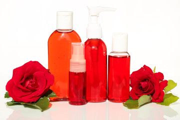 cosmetics with rose extract. set of cosmetics with rose extract  for face skin  and large red roses on a light  background
