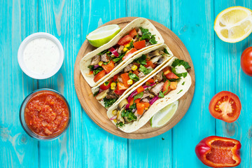 Mexican pork tacos with vegetables. Tacos al pastor on wooden blue rustic background. Top
