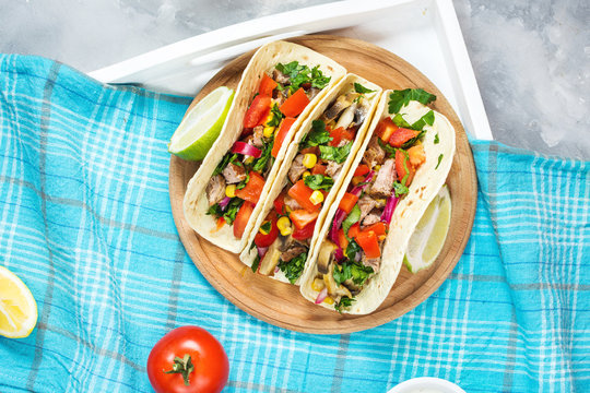 Mexican pork tacos with vegetables. Tacos al pastor on wooden blue rustic background.