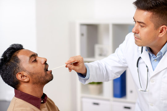 doctor examining patient throat at clinic