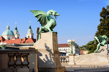 Dragon Bridge with view of Cathedral Saint Nicholas on blue sky,  Ljubljana Slovenia