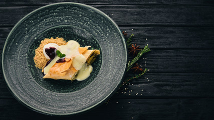 Apple strudel with ice cream. Dessert. On a black wooden background. Copy space.