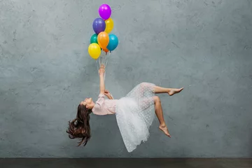 Foto op Canvas young woman levitating with colorful balloons © LIGHTFIELD STUDIOS