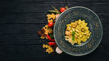 Pasta Farfelli with spinach and seafood. Italian cuisine. Top view. On a black wooden background. Copy space.