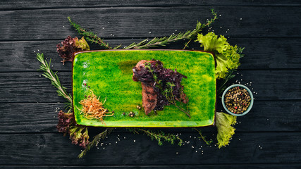 Baked veal fillet with Madeira onion. Hot appetizers. Top view. On a black wooden background. Copy space.
