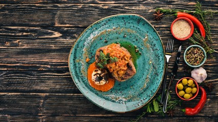 Pork steak grilled with zucchini caviar. Meat. Top view. On a black wooden background. Copy space.