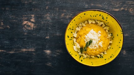 Banosh with cheese. Top view. On a black wooden background. Copy space.