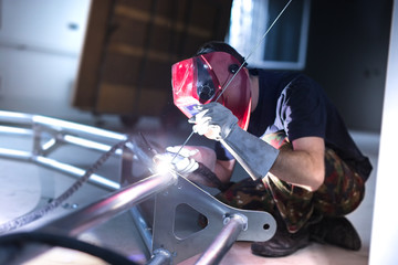 Fototapeta Man welding aluminum construction with TIG welder obraz
