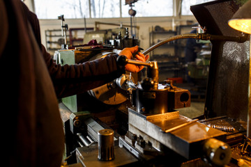 Lathe machine drilling metal in workshop.