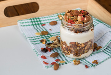 Natural yogurt with granola in small glass jar
