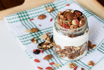 Natural yogurt with granola in small glass jar