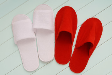 red and white slippers from hotel, red and white slippers from airplane are on white wooden floor, home slippers are on white background, home footwear