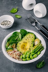 Green vegetarian buddha bowl salad with grilled vegetables and quinoa, spinach, avocado, brussels sprouts, zucchini, asparagus, edamame beans