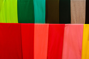 Closeup of colorful scarves hanging in the market.