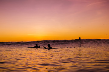 Fototapeta premium Sunset in Bali and surfers waiting for wave in ocean