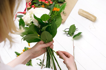 Fototapeta premium Female florist making beautiful bouquet at flower shop