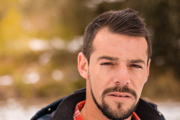 Young man with beard laughing in nature