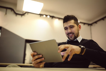 Young businessman using tablet in office.