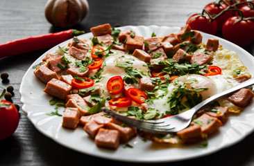 Breakfast. two fried eggs with ham on dark wooden background