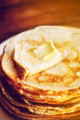 Russian Maslenitsa, Shrovetide, pancake week, carnival, shrove, pancake day. a stack of pancakes with butter upstairs on plate, on wooden background, close-up