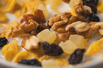 corn flakes with nuts and fruits in white bowl