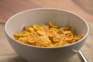 corn flakes in white bowl for breakfast on table
