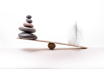 Stone balance with plume. Concept of hard and easy.
