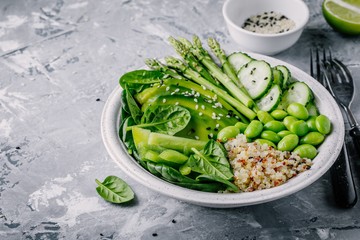 Green vegetarian buddha bowl salad with fresh vegetables and quinoa, spinach, avocado, asparagus, cucumber, edamame beans