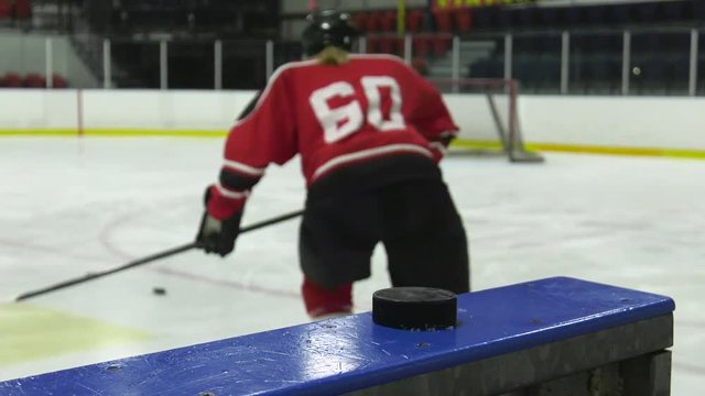 woman hockey player knocks over pyramid of pucks going onto the ice slow motion