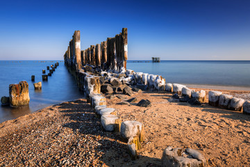 Frozen wooden breakwaters line at Baltic Sea in Poland