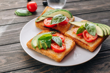 Dietary healthy food. Bread with avacado, tomatoes and Basil