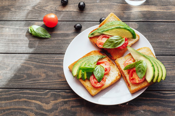 Dietary healthy food. Bread with avacado, tomatoes and Basil