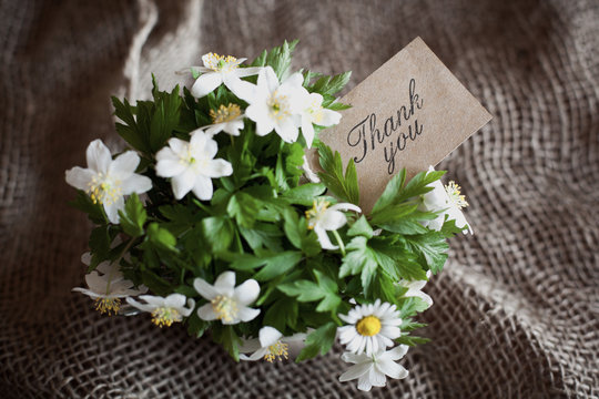 bouquet of spring anemones with a "thank you" card
