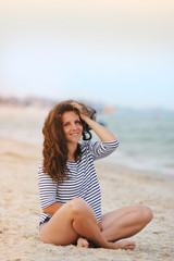 Fototapeta na wymiar young woman sitting on the beach in summer