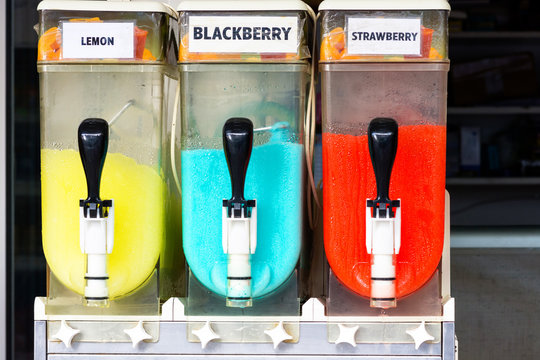 Colorful canisters of refreshing frosty cold slush ice drinks